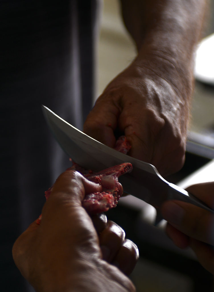 Amir Choudhry cuts meat into smaller bits to be bagged